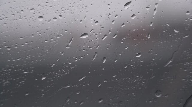 raindrops flowing down on window glass