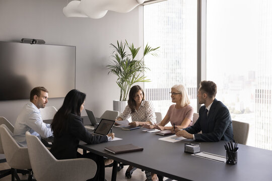 Group of professionals discussing business matters, strategy, or new project details during collaborative meeting, brainstorming session, or negotiations, involving strategic decisions and teamwork