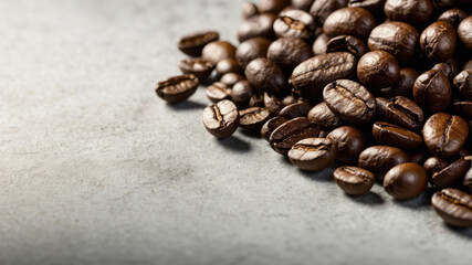 Naklejka premium Roasted coffee beans forming a pile on gray background