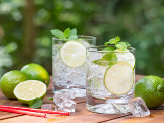 Glass of sparkling water with lime slices and mint leaves