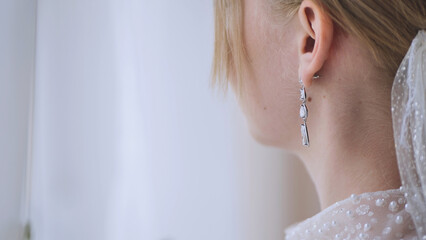 Close up of a bride's elegant earrings, adding a touch of sparkle to her wedding day look