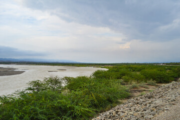 river water side dirt road in the countryside, landscape nature trees rain season