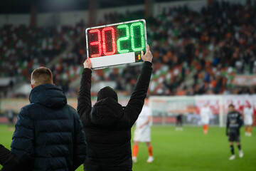 Team manager shows players substitution during football match.