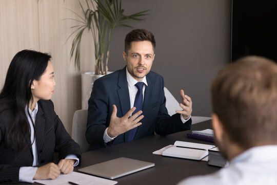 Boss leading negotiations, conducting collaborative meeting, explain details, reviewing business strategies, performance metrics, or future plans, exchanging ideas, engaged in productive discussion