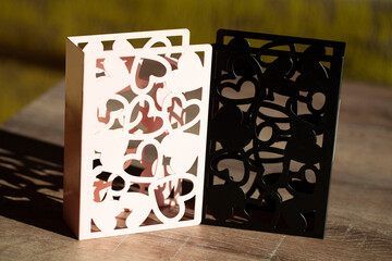 Dual Heart Vases: Light and Shadow Dance Through Cutout Designs, A Study in Contrast and Delicate Patterns on Wood, Evoking Modern Elegance and Subtle Romance