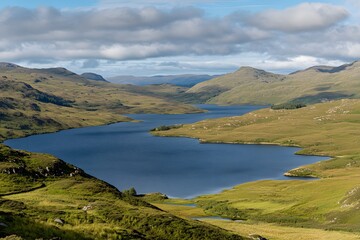 Serene loch amidst rolling green hills under a partly cloudy sky
