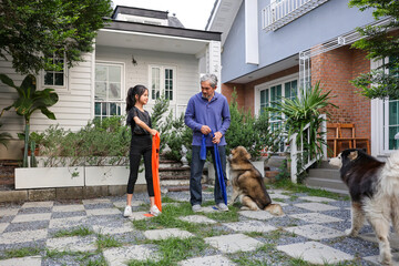 Young asian kindergarten girl is doing exercise with her grandfather in the backyard garden for healthy and sport