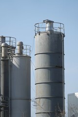 Silosy cementowni z widocznymi drabinami pionowymi