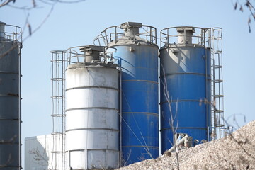 Silosy cementowni z widocznymi drabinami pionowymi