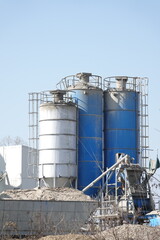 Silosy cementowni z widocznymi drabinami pionowymi
