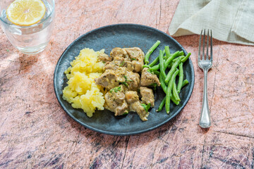 Creamy pork and mushrooms with boiled potatoes and green beans