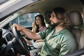 Young couple enjoying a road trip in a car, with a relaxed atmosphere and the man focused on driving The woman appears cheerful and engaged