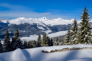 Fototapeta premium Snow-covered Alps under a bright blue sky with lush evergreen trees