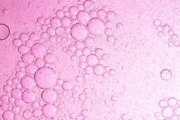 Macro pink bubble texture,Pink skincare background. Water toner serum oil surface with bubbles. Abstract cosmetic liquid macro,Abstract pink oil bubbles background. Cosmetic liquid beauty product.