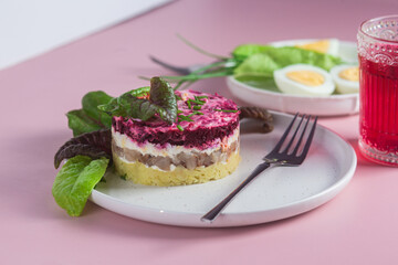Salad with herring and beets in a plate. Salad Herring under a fur coat