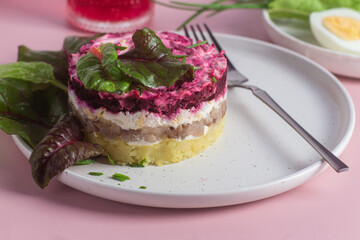 Salad with herring and beets in a plate. Salad Herring under a fur coat