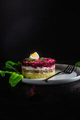 Salad with herring and beets in a plate. Salad Herring under a fur coat