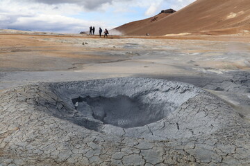 dark grey mud boiling and fuming in a geothermal mud pot in Namaskard geothermal area in Iceland