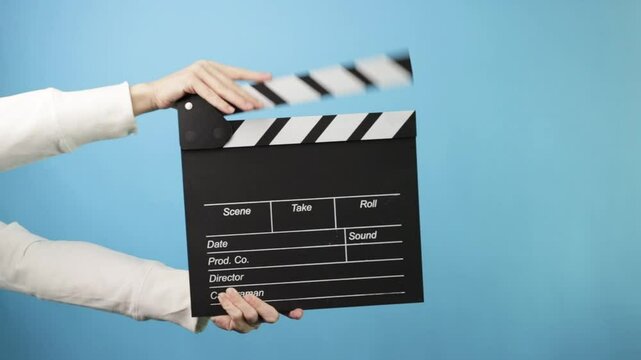 Clapperboard in action, filmmaking process, director marking a scene in a film production