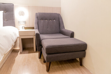 A plush and stylish motel sofa sits elegantly in a cozy, dimly lit room, offering both comfort and sophistication. The sleek design, soft upholstery, and inviting cushions create a relaxing atmosphere