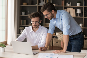 Mentoring in family business. Confident young freelance working businessman student help consult...