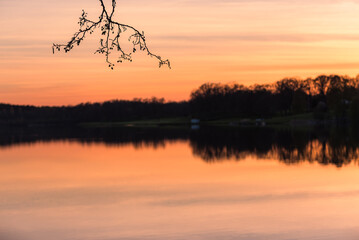 Naklejka premium Spring sunset reflects on calm water near Åtvidaberg village in Sweden