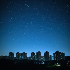 Naklejka premium Captivating view of a city skyline at night silhouetted against a starry sky creating a beautiful urban landscape scene