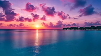 Sunset over tranquil waters with pink and purple clouds in a tropical paradise