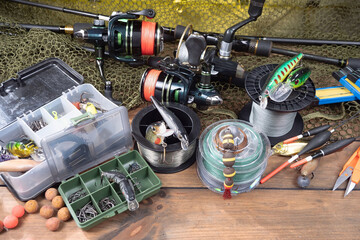 Fishing items laid out on a table against a wooden, old background.