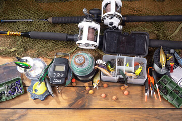 Fishing items laid out on a table against a wooden, old background.