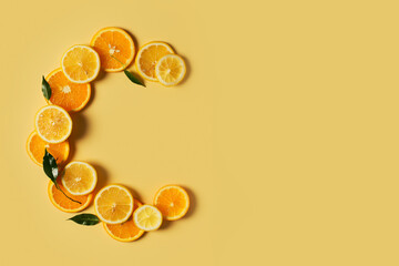 Serum bottle and orange slice on yellow background