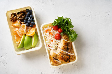 Lunch box with chicken, rice, vegetables, tomatoes, salad, fruits