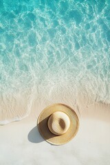 Tropical beach scene with straw hat on white sand meeting turquoise water. Relaxing beach day vibes.