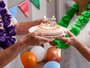 Joyful 75th birthday party, a moment of joy to share with a slice of cake for two elderly people in the family