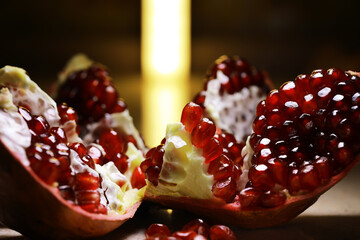 Close-Up of Fresh Ripe Pomegranate with Juicy Red Seeds and Dramatic Lighting