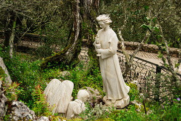 Stone statues in serene forest setting, Fatima, Portugal, spiritual and peaceful view