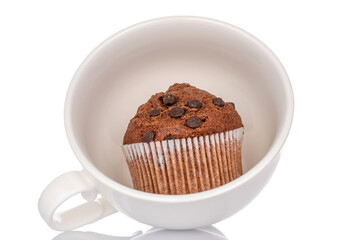 One chocolate cupcake with ceramic cup, isolated on white background, close-up.