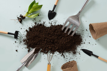 Various gardening hand tools around soil on blue background. Spring gardening. Concept season...