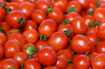Fresh ripe tomatoes piled high at a vibrant farmer's market during the sunny afternoon in late summer