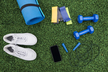fitness equipment on green grass background. Sports equipment, sports accessories on grass. Concept of sports, fitness.