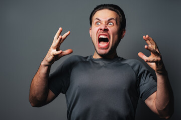 Angry man emotional aggressive portrait on gray background