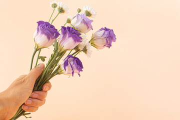Woman's hand holding bouquet of lisianthus flowers