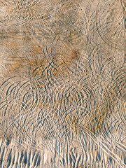 Ślady opon na suchym piasku, widok z góry  
