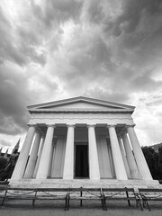 Czarno-biały neoklasycystyczny świątynny budynek z dramatycznymi chmurami – architektura w greckim stylu



