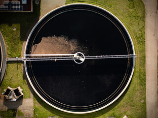 Widok z góry dużego okrągłego zbiornika ściekowego z warstwami osadu  © Kacper