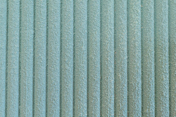 A close-up texture of soft, light blue corduroy fabric with parallel ridges, showcasing a tactile and cozy textile pattern