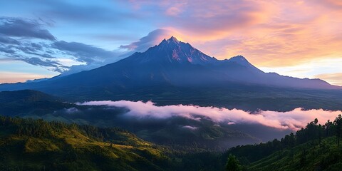 Majestic mountain peak emerging through misty clouds at dawn