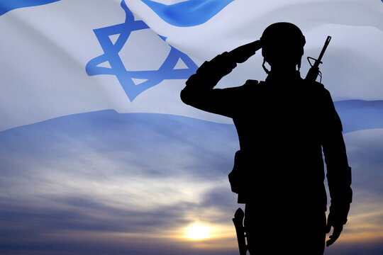 Silhouette of soldier against the sunset with Israel flag. National Holidays concept
