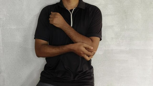 Young adult person suffering with elbow joint pain massaging the area. Closeup view. Tennis elbow, ligament injury, arthritis, chronic ache, golfers elbow and epicondylitis medical condition concept.