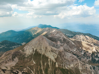 Bulgaria Pirin Mountains seen from drone, showcasing high-altitude peaks, rolling clouds, and...